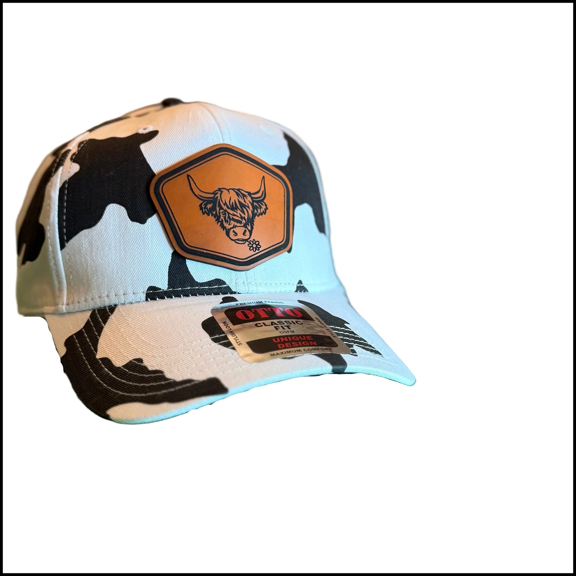 A white baseball cap with a black cow print pattern and a brown patch featuring a bull logo, 