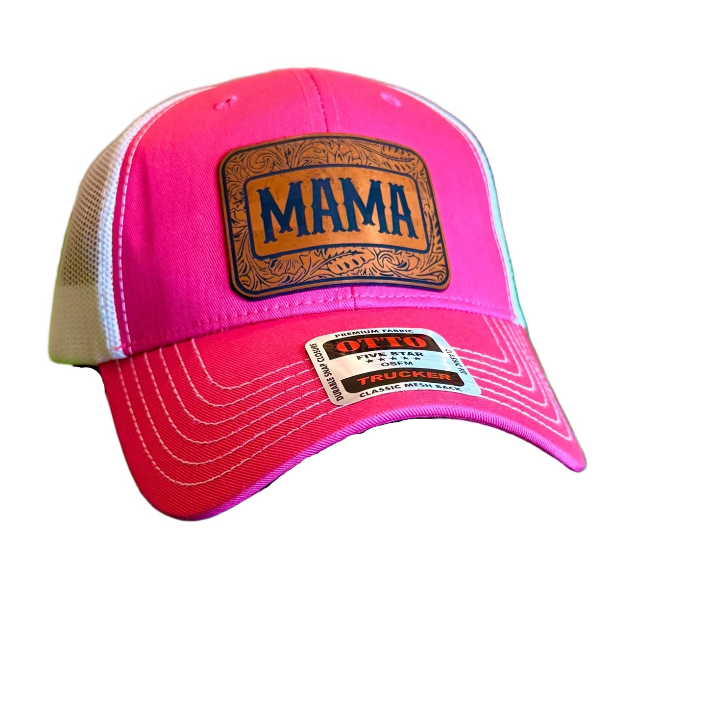 A pink and white trucker hat with a brown leather patch reading 'MAMA' in black letters.