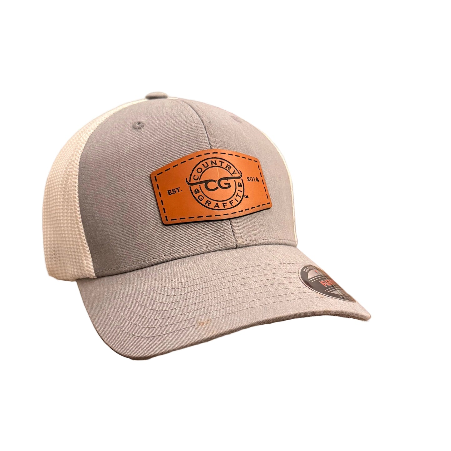 A gray and white trucker hat with an orange-brown leather patch on the front.