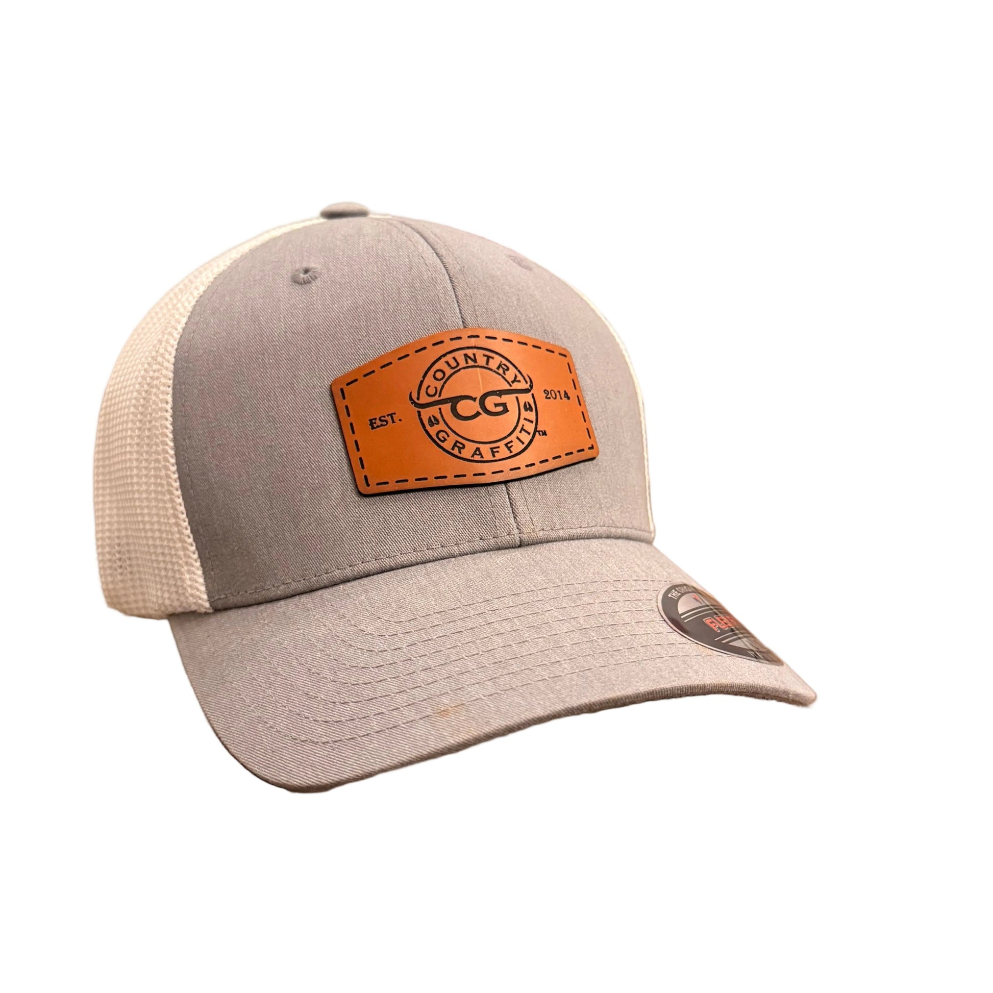 A gray and white trucker hat with an orange-brown leather patch on the front.